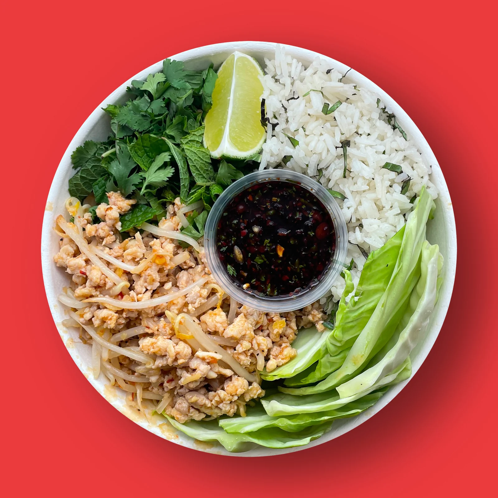 Larb Gai Chicken: Lemongrass marinated ground chicken, Thai basil rice, vegetables, cabbage cups, soy bean sauce