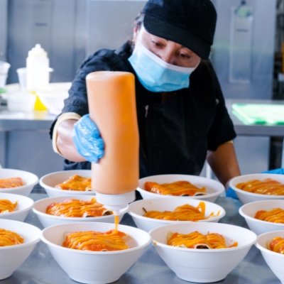 Superfine Kitchen chef finishing individually packaged corporate lunch in San Francisco kitchen