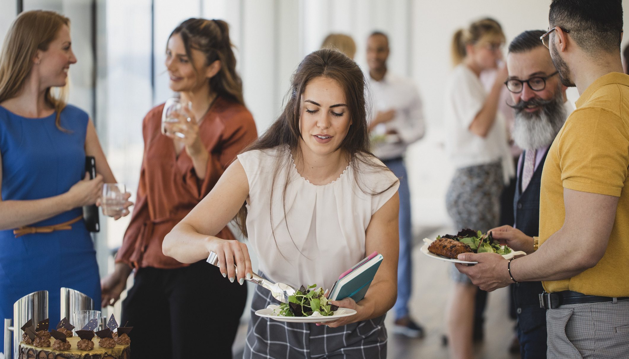 Young woman serving herself at corporate buffet