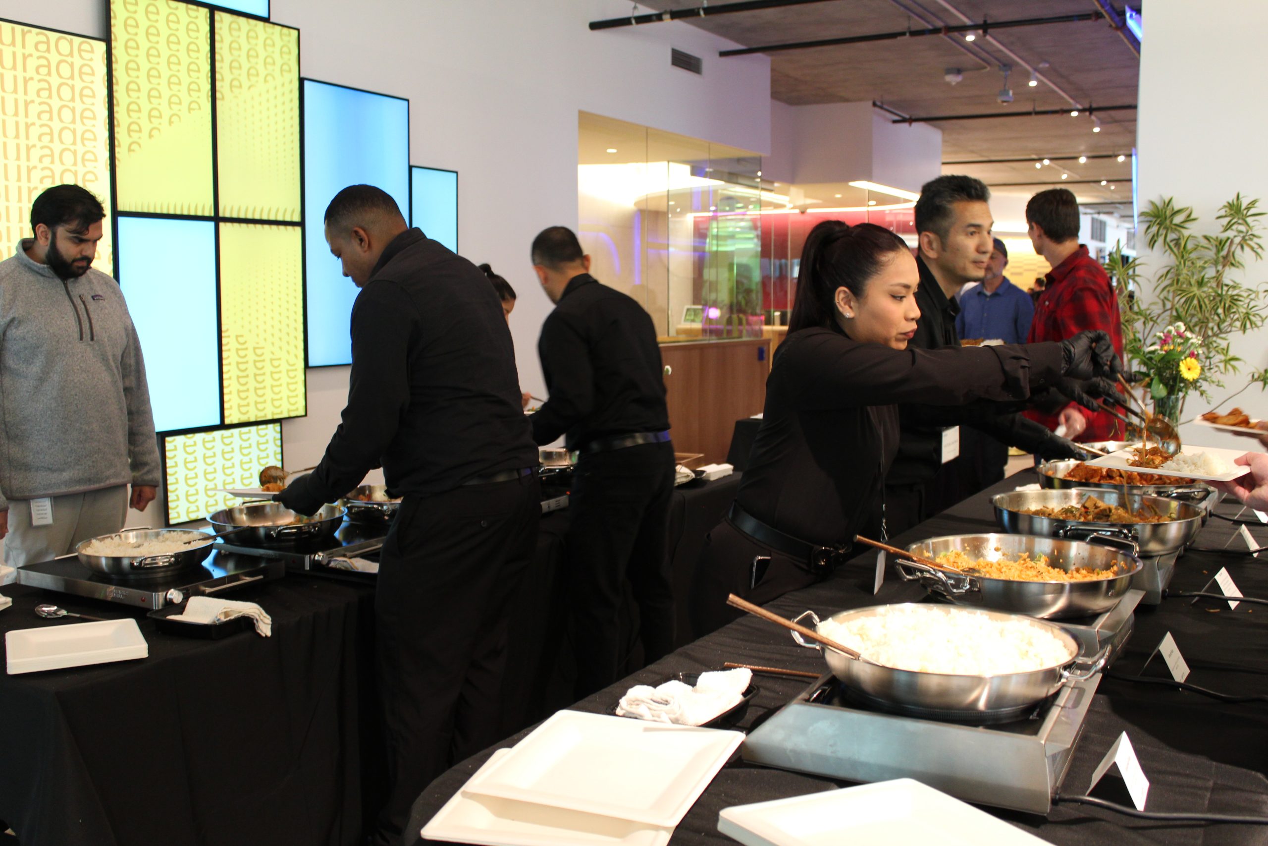 Family style corporate catering San Francisco — Superfine Kitchen staff serving mirrored buffet with chafing dishes at corporate office event