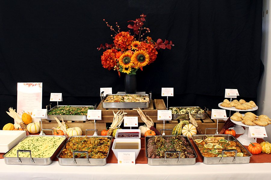 Full Thanksgiving buffet table with turkey, sides, salmon, steak and pies